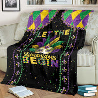Black Mardi Gras blanket on cream sofa with mask, beads, fleur-de-lis and 'Shenanigans Begin'