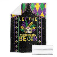 Black Mardi Gras blanket folded with mask graphic, fleur-de-lis beads and 'Begin' text