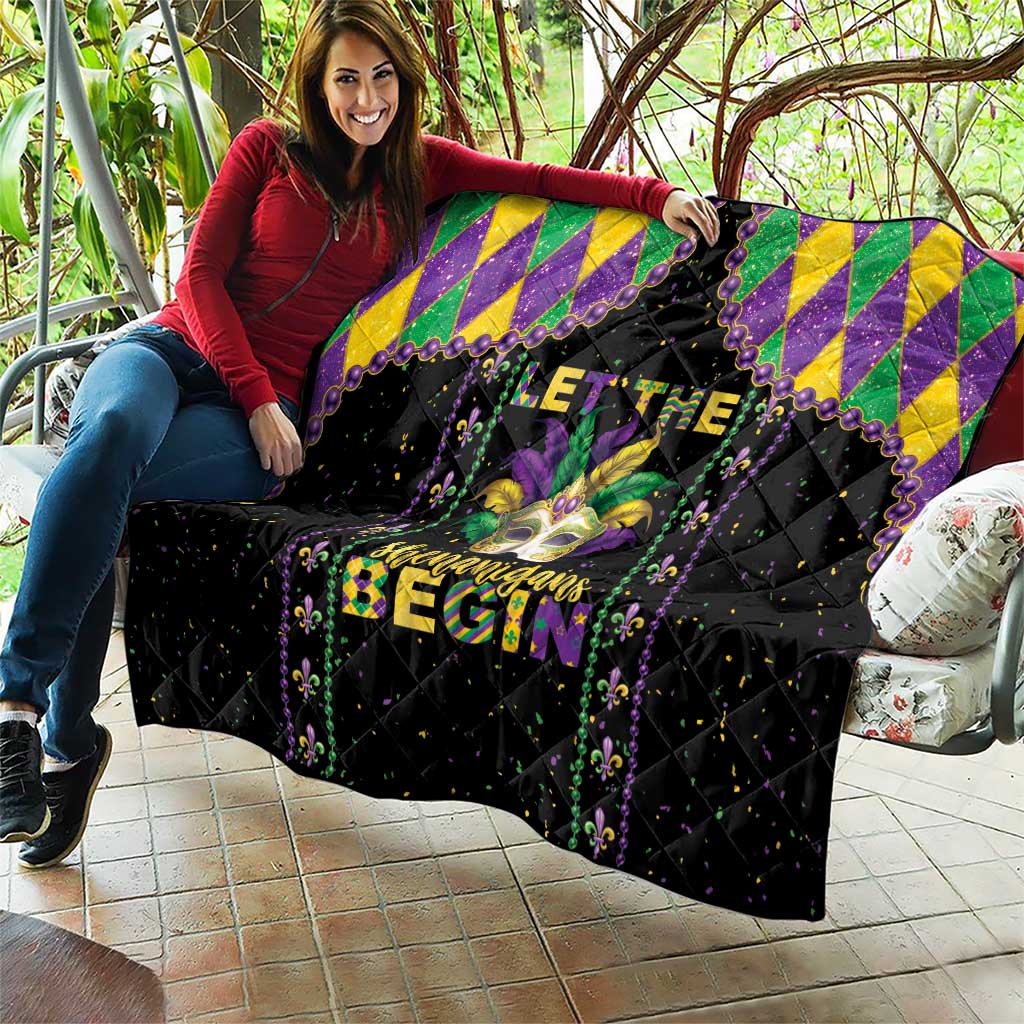 Black Mardi Gras quilt held on sofa with purple, yellow, and green diamond border and fleur-de-lis
