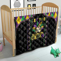 Black Mardi Gras quilt on toddler bed with purple and green diamond border and fleur-de-lis print