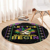 Round black Mardi Gras carpet featuring mask artwork and “shenanigans begin” text