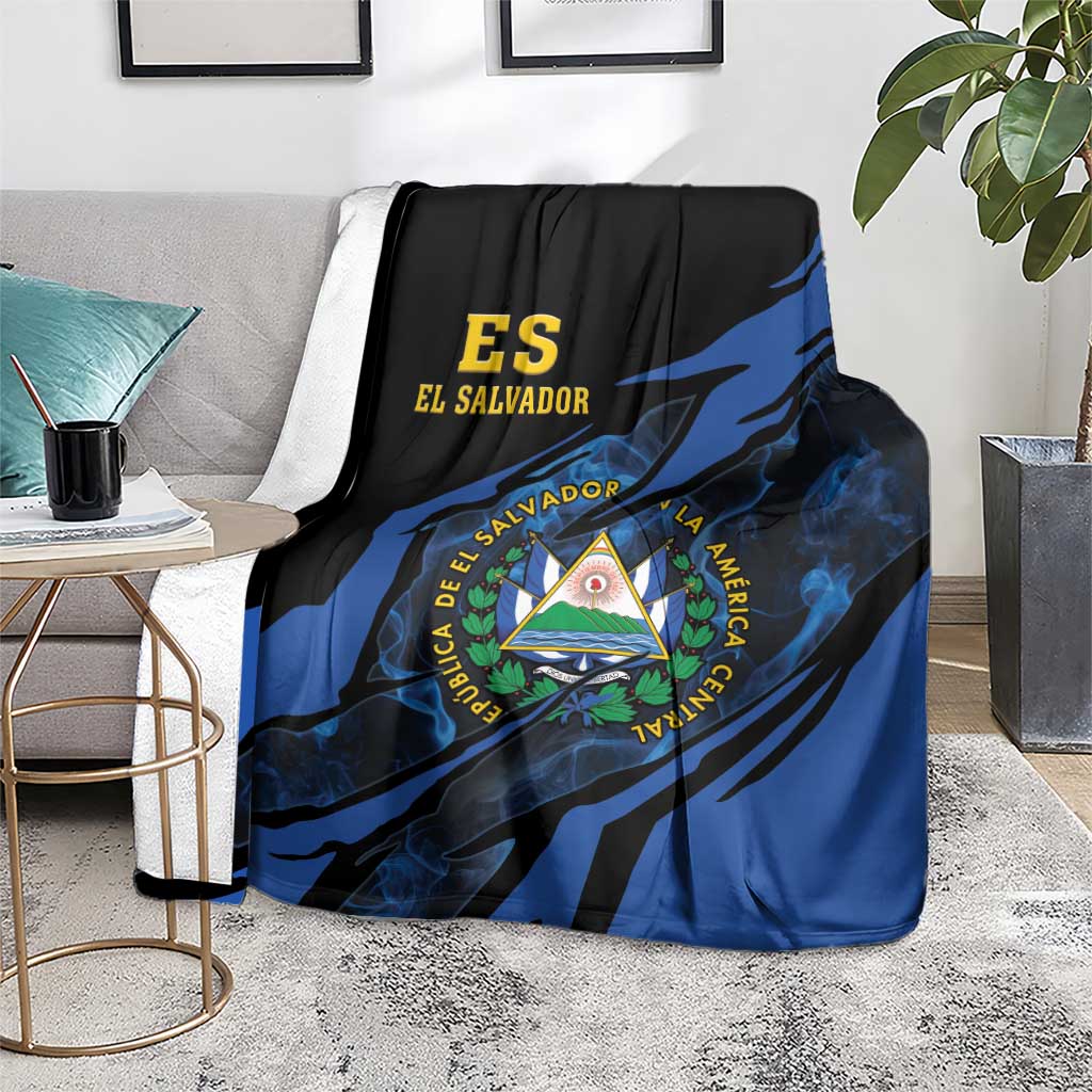 Black and blue El Salvador blanket with coat-of-arms triangle emblem, over couch