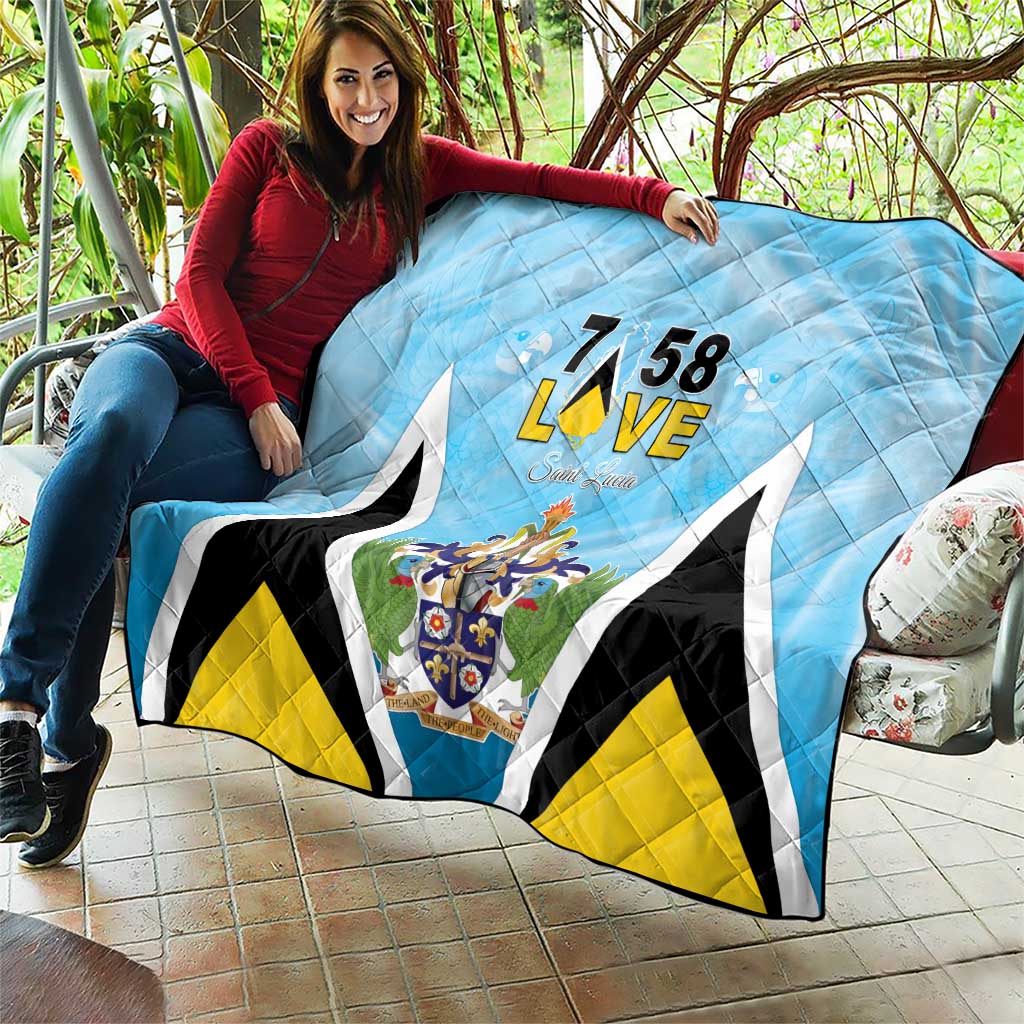 Light blue quilt blanket with “7 58 L•VE” text, Saint Lucia crest, and bold black trim