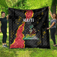 Black quilt blanket spread outdoors, showing Haiti map and colorful coat of arms