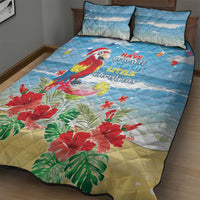 Blue quilt bed set with macaw parrot, beach Christmas text, and tropical floral leaves