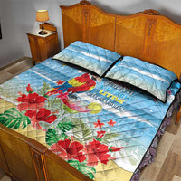 Blue quilt bed set with macaw, red flowers, and 2 matching pillows on the bed