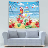 Blue Christmas beach tapestry with macaw parrot, red flowers, palm leaves, and bunting lights