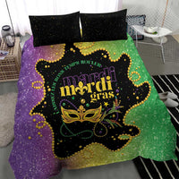 Mardi Gras bedding set with central mask graphic on purple-green duvet and black speckled pillows