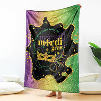 Colorful Mardi Gras blanket draped on couch, black center with gold mask and beads