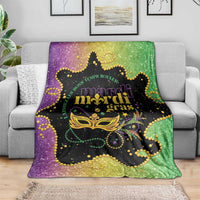 Colorful Mardi Gras blanket on gray sofa, black panel with gold mask and purple-green edges