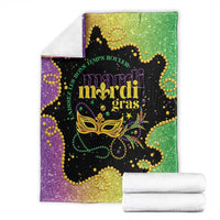 Colorful Mardi Gras blanket folded with stacked white towels, purple-green glitter mask print
