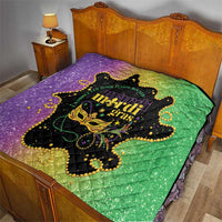 Mardi Gras quilt laid on bed in purple and green with black mask and gold fleur motifs