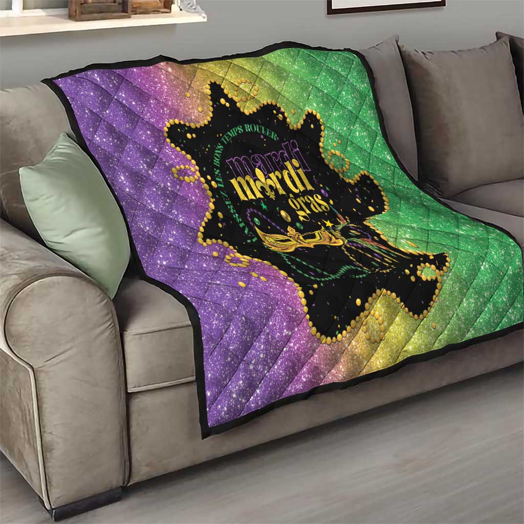 Mardi Gras quilt folded on sofa in purple and green with black mask graphic