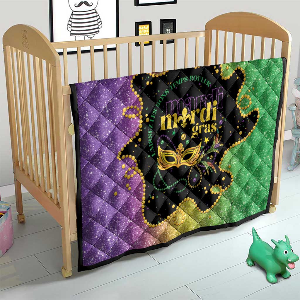 Mardi Gras quilt on crib in purple and green with black mask and gold Mardi Gras text