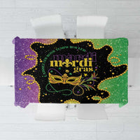 Mardi Gras tablecloth with purple, green, black, and gold glitter print centered on table