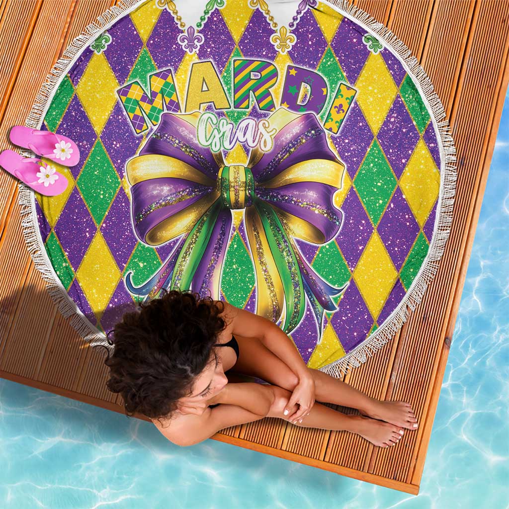 Round Mardi Gras beach blanket with glitter diamond pattern, large bow graphic, and fringe trim