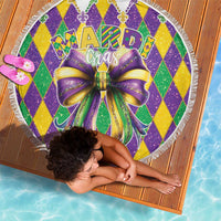 Round Mardi Gras beach blanket with glitter diamond pattern, large bow graphic, and fringe trim