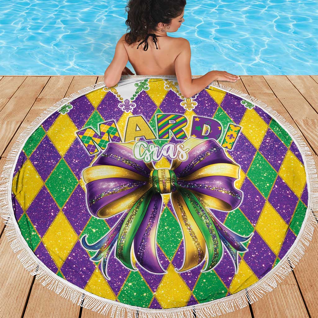 Round Mardi Gras beach blanket with glitter diamond pattern, large bow graphic, and white fringe