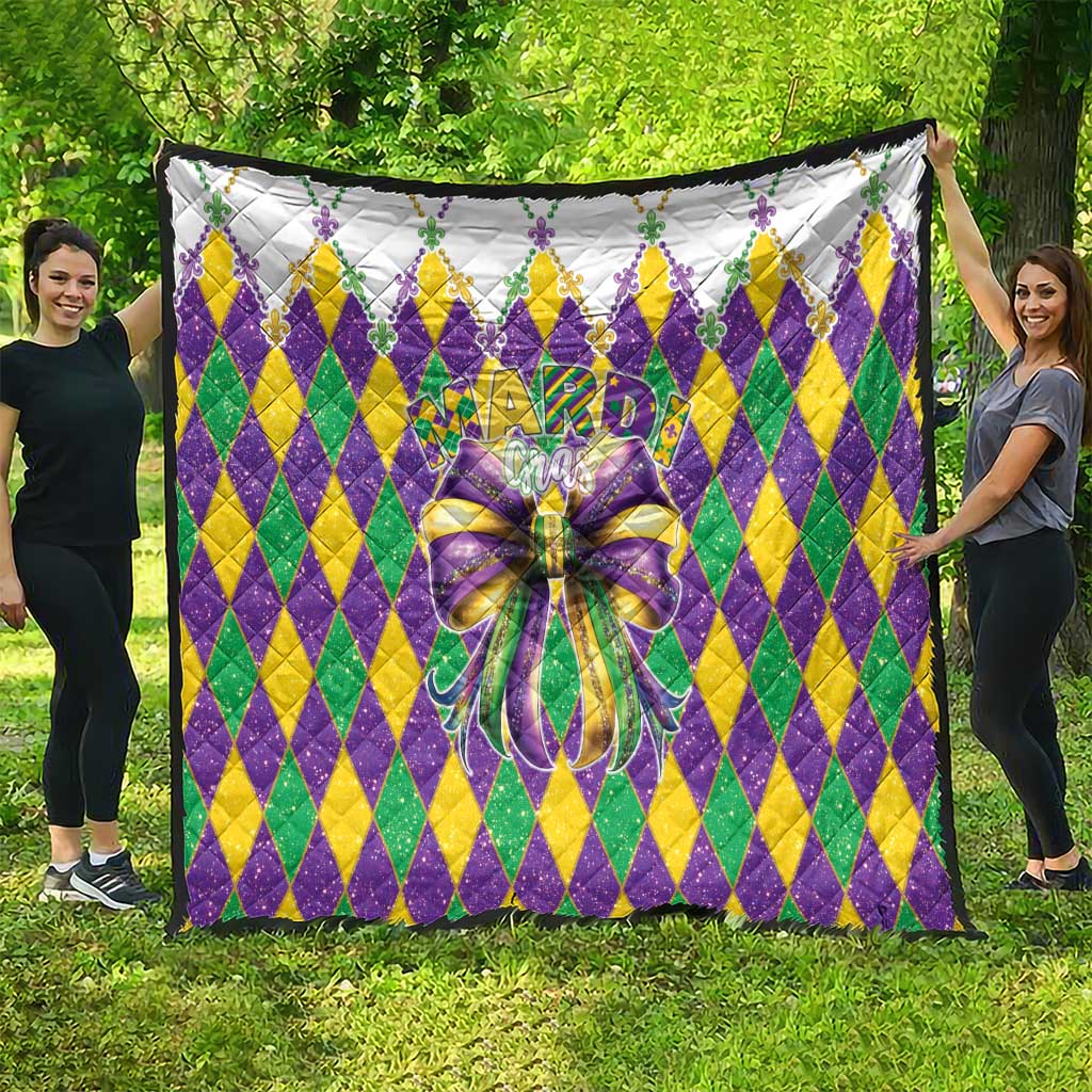 Colorful diamond-pattern quilt with large multicolor bow, shown spread flat