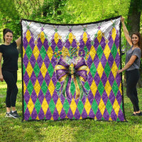Colorful diamond-pattern quilt with large multicolor bow, shown spread flat
