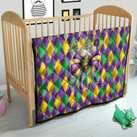 Colorful diamond-pattern quilt with large multicolor bow in a baby bed