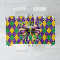 Mardi Gras tablecloth with purple/green/gold diamond pattern and glitter bow centerpiece