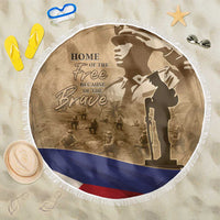 Round brown beach blanket with white fringe, patriotic soldiers graphic and 'HOME OF THE Free'