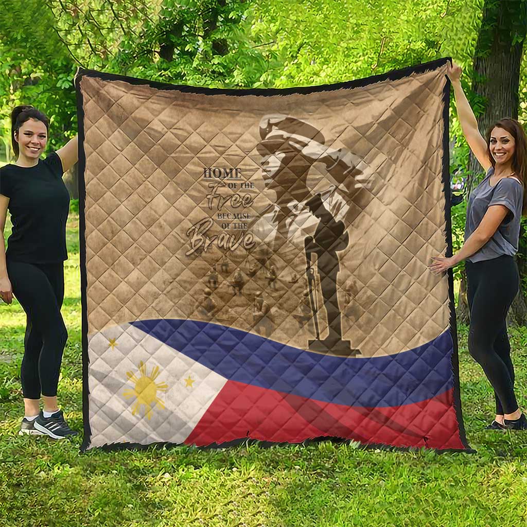 Tan quilt hanging outdoors with soldier silhouette, flag stripes band, and diamond quilting
