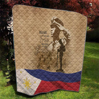 Tan memorial quilt on grass with soldier silhouette, 'Home of the Brave' text, and flag stripes