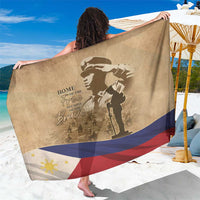 Brown sarong spread out showing soldier silhouette, memorial lettering, and flag border