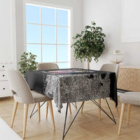 Black grunge-style tablecloth with distressed print design draped over dining table