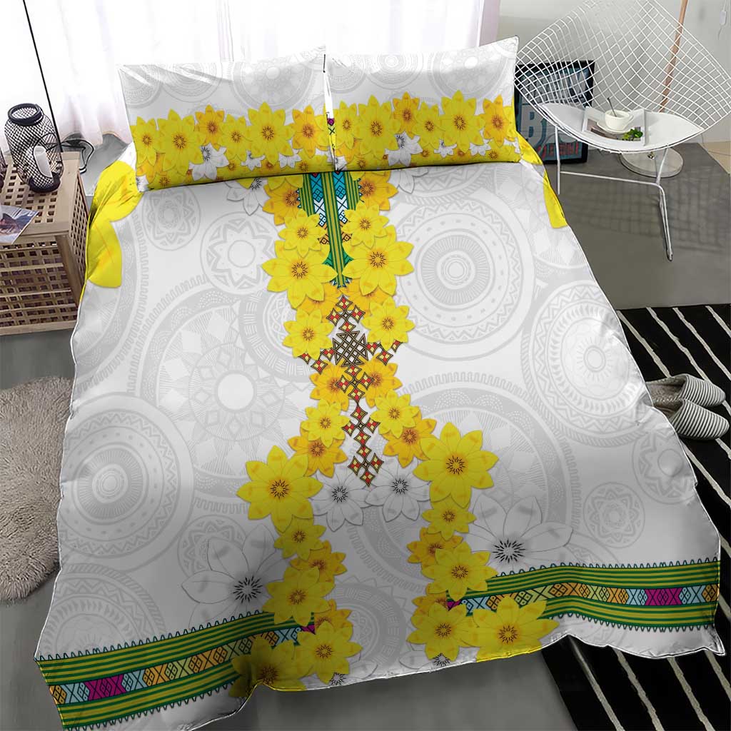 White duvet cover with yellow flower cross design, matching pillowcases, and patterned bottom border