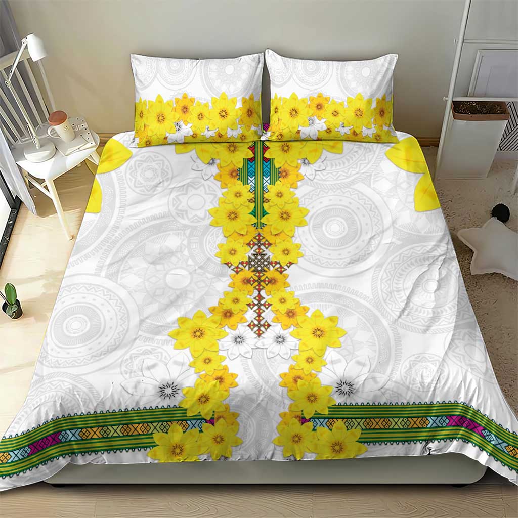 White bedding set with yellow floral cross center, two pillowcases, and multicolor stripe edging