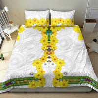 White bedding set with yellow floral cross center, two pillowcases, and multicolor stripe edging