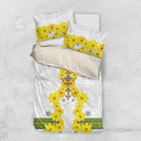 Folded white bedding set with yellow flower cross print and matching pillowcases, multicolor trim