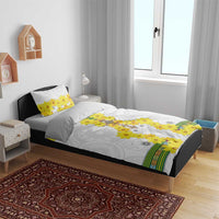 White duvet on bed with yellow floral cross pattern and two small matching pillows, multicolor border