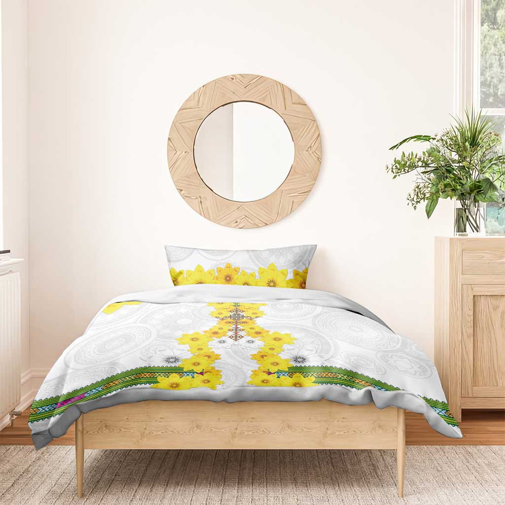 White bedding set on wooden bed frame with yellow flower cross duvet and matching pillow, striped border