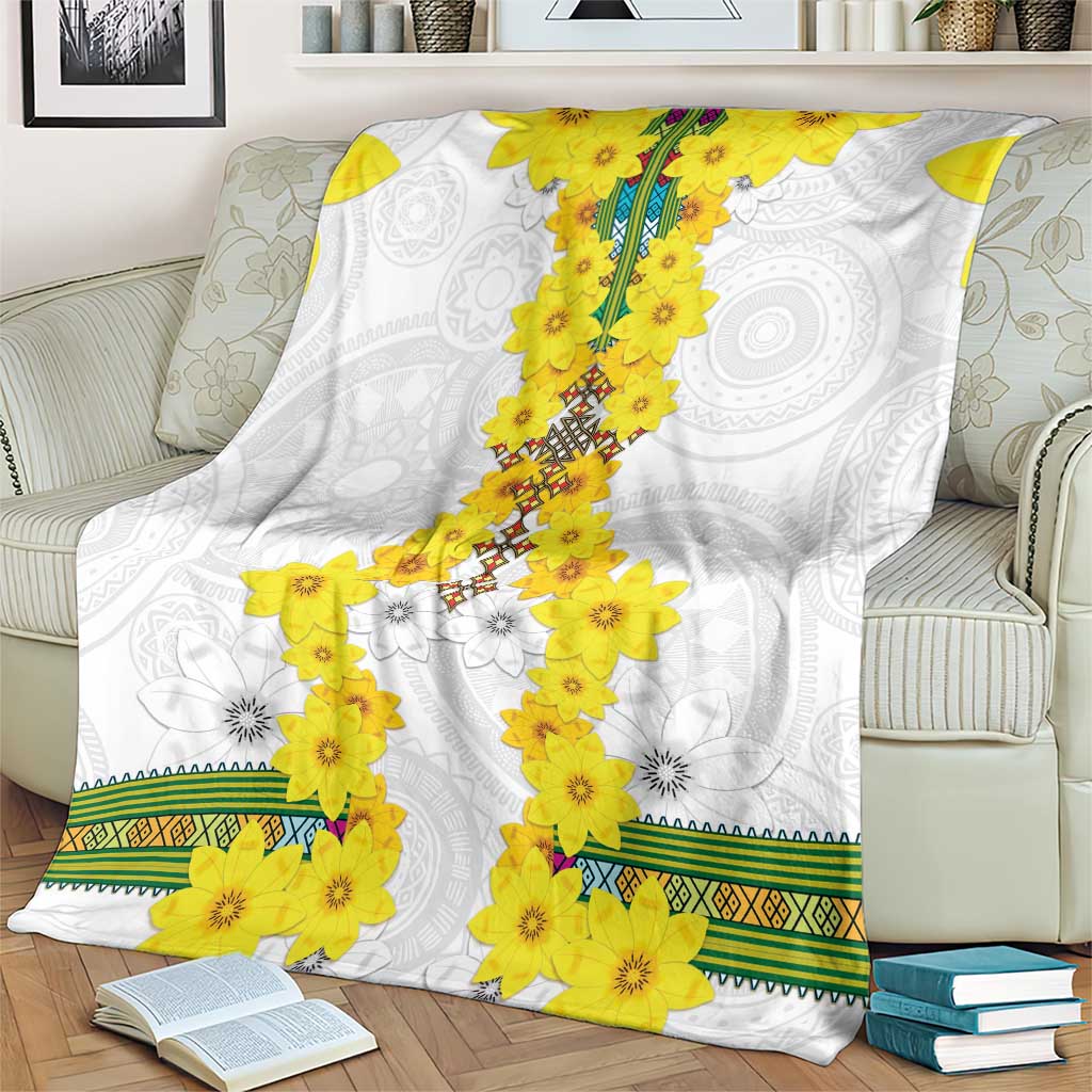 White blanket with yellow flower clusters, gray medallion swirls, and green woven border
