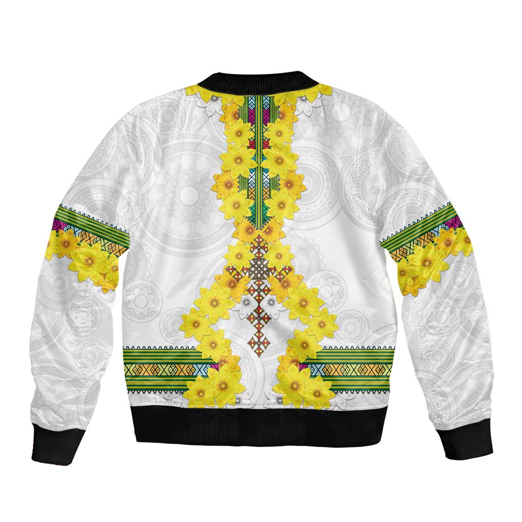 White bomber jacket with yellow floral tile center panel, green-trim bands, black ribbed hem
