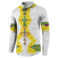 White long-sleeve sweatshirt with yellow floral motif and multicolor striped sleeve bands.