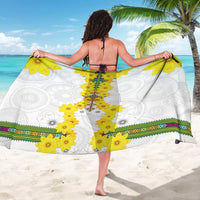 White sarong with yellow flower vertical motif and green patterned hem border, worn.