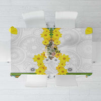 White tablecloth with yellow flower centerpiece and green geometric border