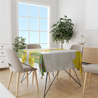 White tablecloth with yellow flower print and green geometric border across top