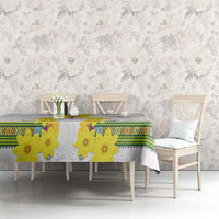 White tablecloth with yellow blossoms and green border pattern on dining table