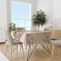Beige tablecloth on dining table with diamond pattern and rose prints.