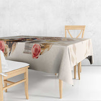 Beige tablecloth draped over a table, showing rose print and diamond accents.