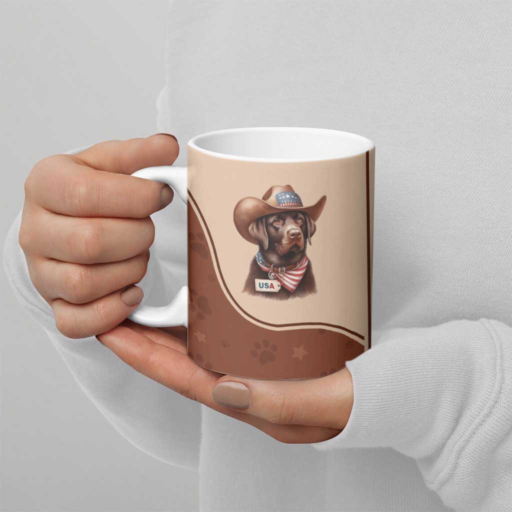 Brown ceramic mug with cowboy dog USA graphic, held in both hands over light background