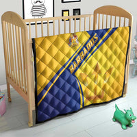 Barbados quilt on a toddler bed, gold and blue diagonal stripe with coat of arms