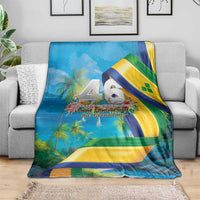 Blue flag-themed blanket on gray sofa with 46 Years of Independence bird emblem