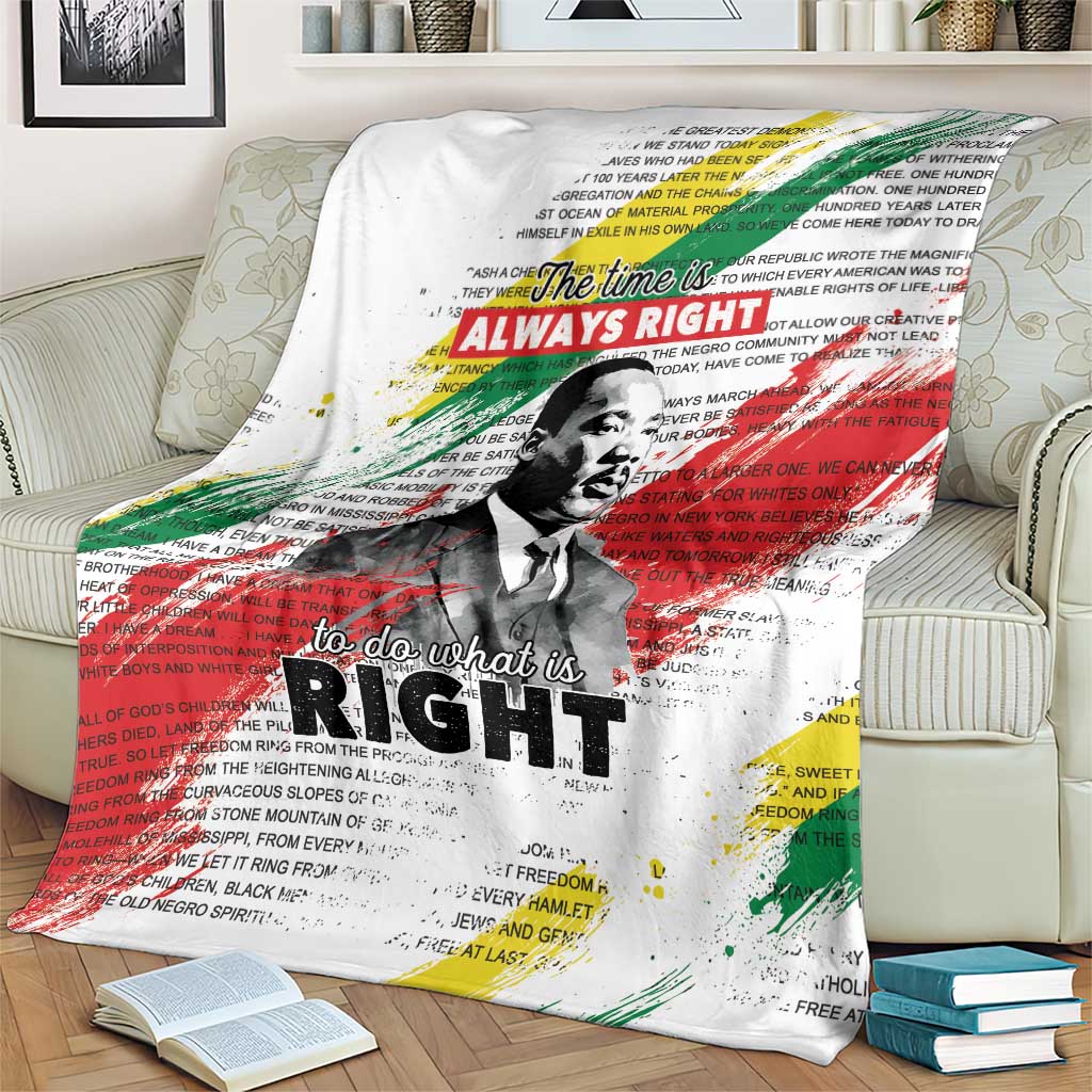 White MLK tribute blanket with multicolor splashes and portrait, folded over sofa arm